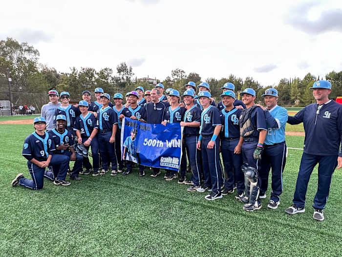 Granite Hills head coach James Davis celebrates with his team after picking up career victory No. 500 on Wednesday afternoon